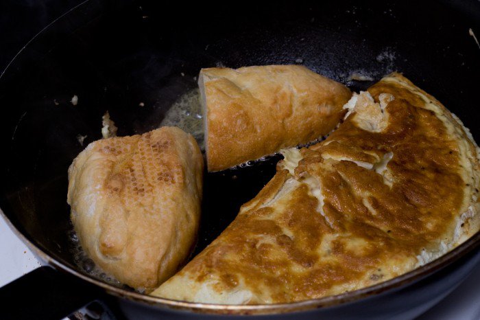 Omeletten foldet halvt sammen, mens to skiver flutes lige steges sprøde