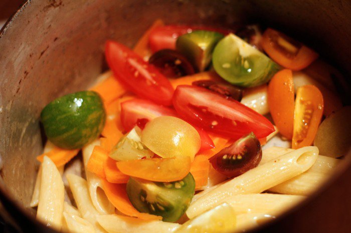 Dump venligt tomaterne ned i gryden til pastaen