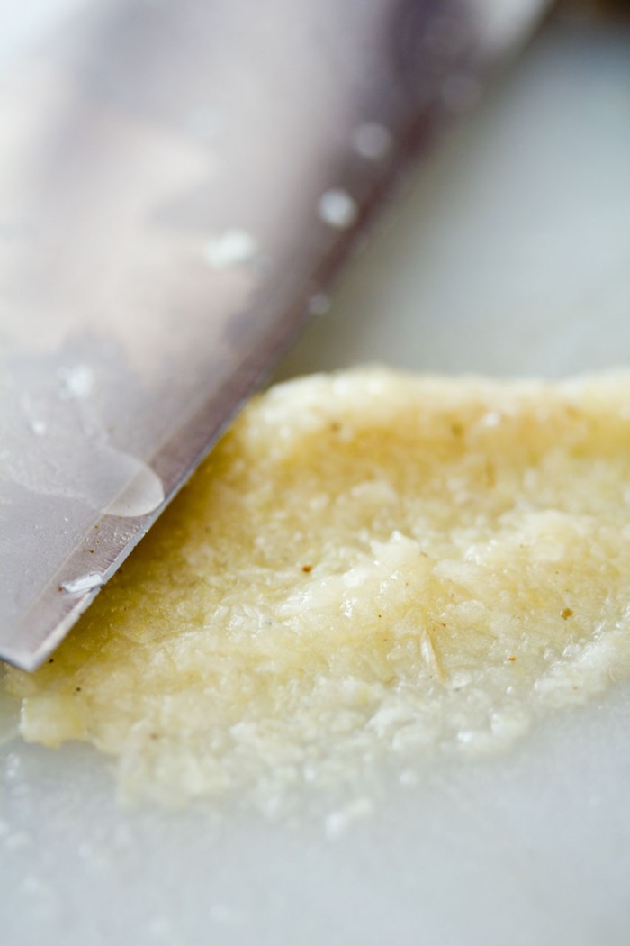 Kvas hvidløget til en fin mos med et knivsblad og lidt hjælp fra salt